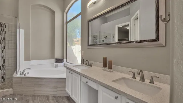 a bathroom with a tub sink and mirror