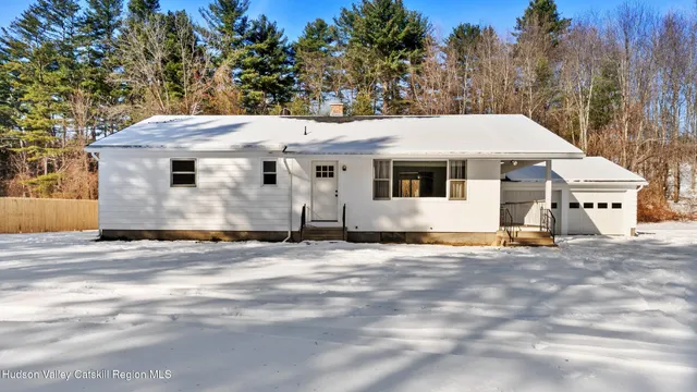 a view of a white house with a large trees