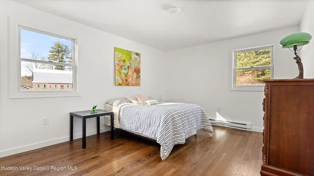 a bedroom with a bed and painting on the wall