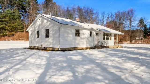 a view of a white house with a yard