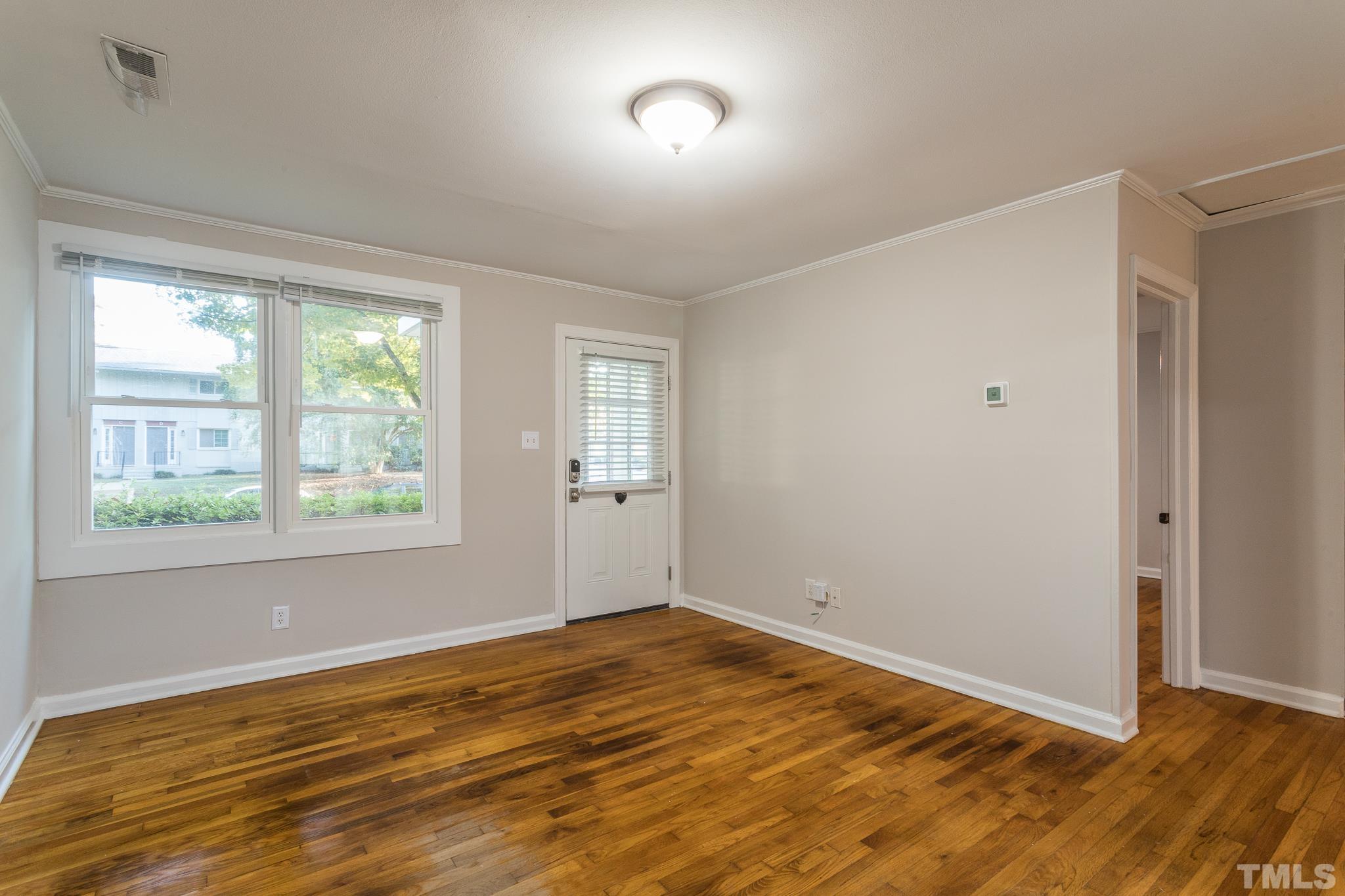 2620 McNeil Street, Unit 2620 Raleigh, NC 27608 - Photo 13 of 23 a view of an empty room with wooden floor and a window