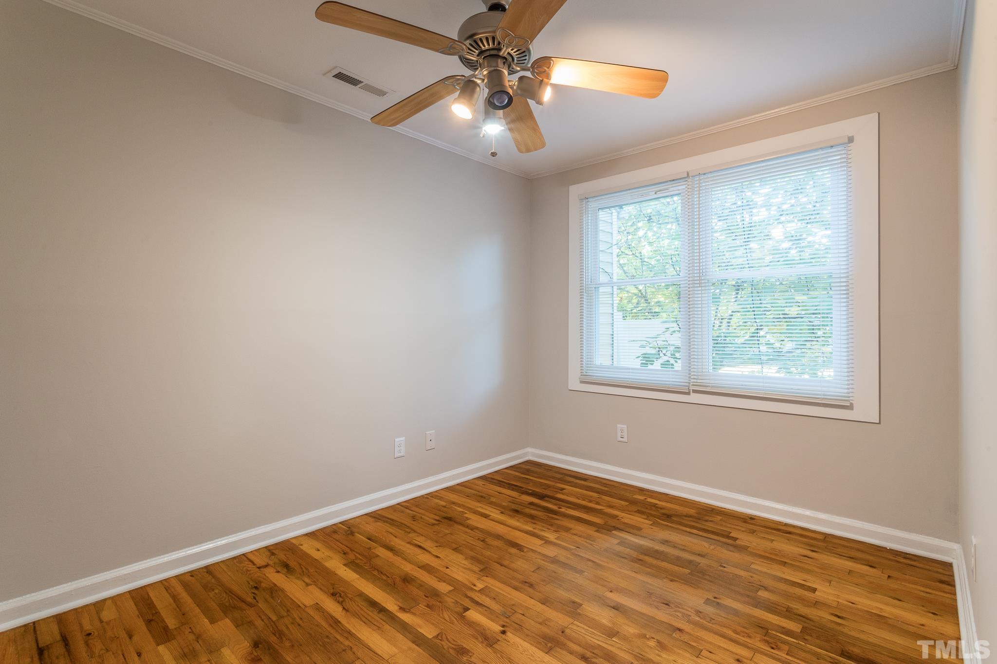 2620 McNeil Street, Unit 2620 Raleigh, NC 27608 - Photo 17 of 23 a view of an empty room with window and chandelier fan
