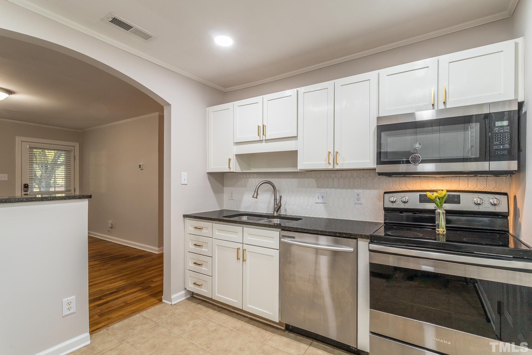 2620 McNeil Street, Unit 2620 Raleigh, NC 27608 - Photo 3 of 23 a kitchen with stainless steel appliances granite countertop a sink and a stove