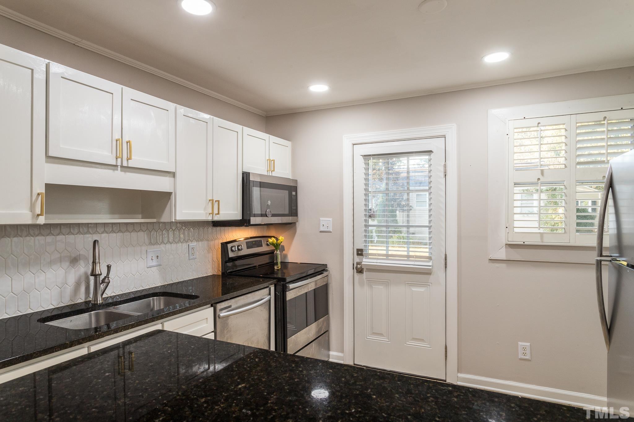 2620 McNeil Street, Unit 2620 Raleigh, NC 27608 - Photo 4 of 23 a kitchen with stainless steel appliances granite countertop a refrigerator and a sink