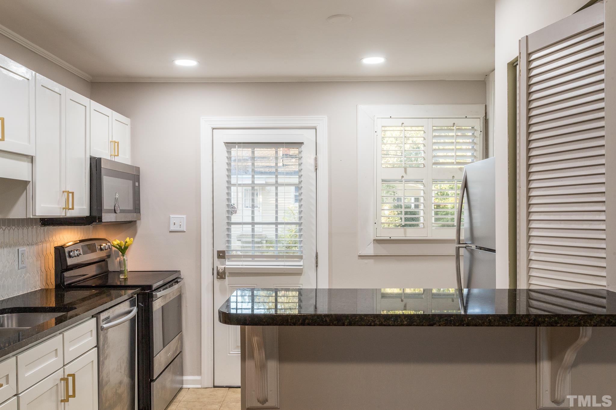2620 McNeil Street, Unit 2620 Raleigh, NC 27608 - Photo 6 of 23 a kitchen with granite countertop a stove and a sink