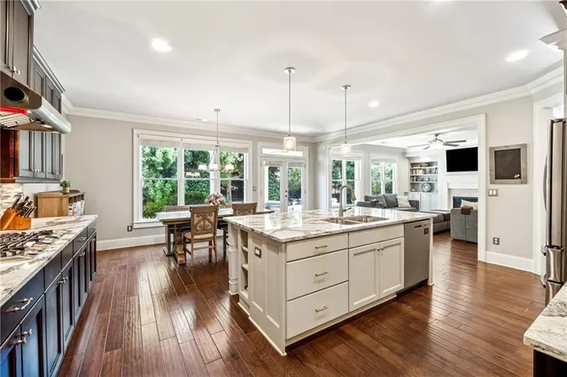a open kitchen with stainless steel appliances granite countertop sink stove top oven and cabinets