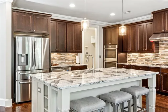 a kitchen with granite countertop a refrigerator and wooden cabinets