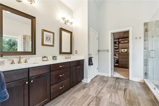 a spacious bathroom with a double vanity sink a large mirror and a shower