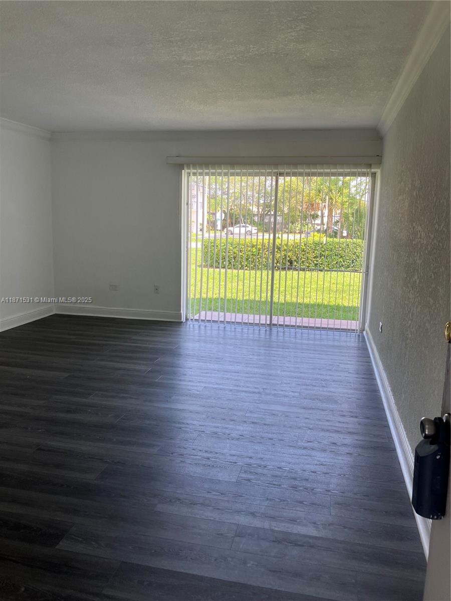 7256 Southwest 94th Place, Unit A1 Miami, FL 33173 - Photo 1 of 7 a view of an empty room with wooden floor and a window