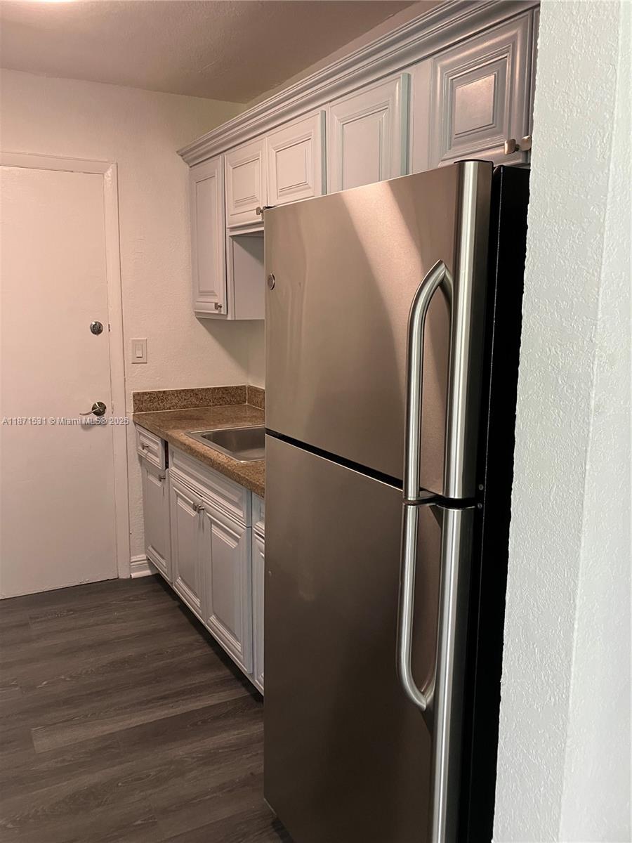 7256 Southwest 94th Place, Unit A1 Miami, FL 33173 - Photo 4 of 7 a white refrigerator freezer sitting inside of a kitchen