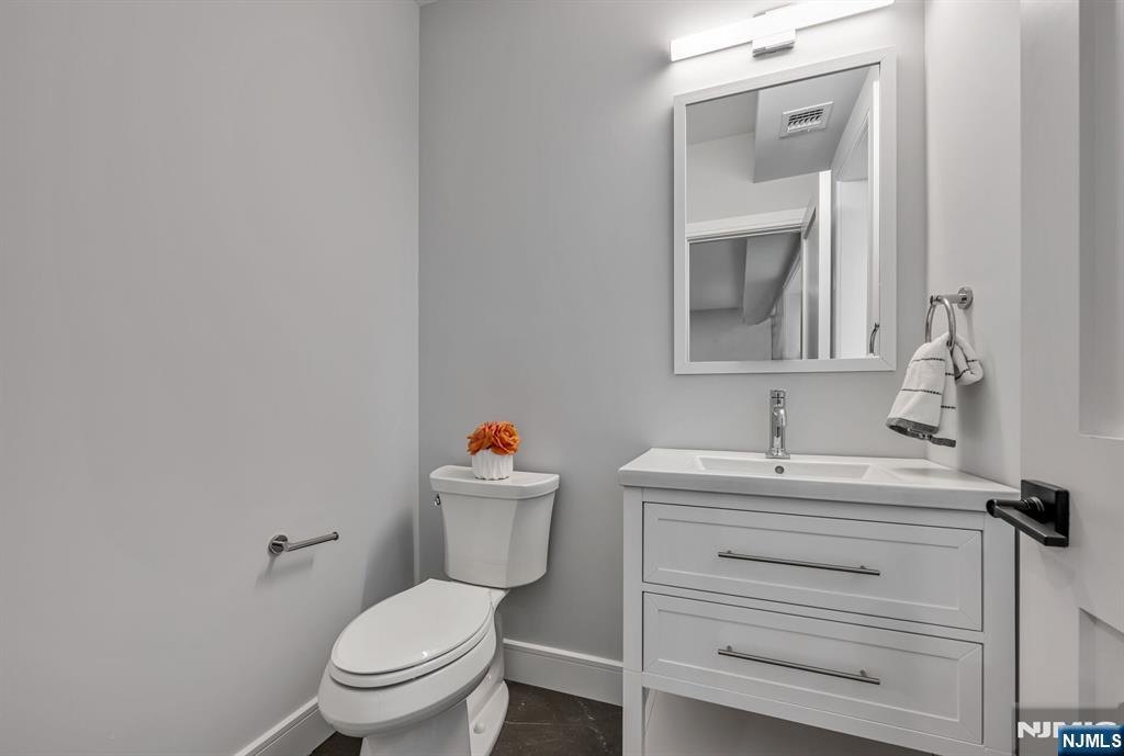 2449 Camner Street Fort Lee, NJ 07024 - Photo 39 of 47 a bathroom with a toilet sink vanity and mirror