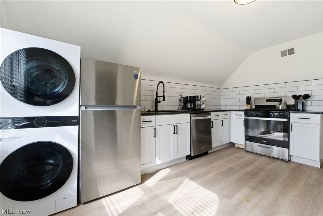 3326 East Overlook Road Cleveland Heights, OH 44118 - Photo 20 of 29 Corner kitchen featuring white cabinetry, dark countertops, white subway tile backsplash, and wood-finish flooring