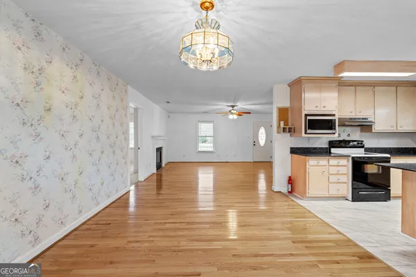 a view of an empty room with chandelier fan and a fireplace