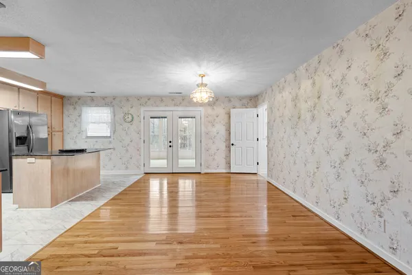 a view of an empty room with chandelier fan and fire place