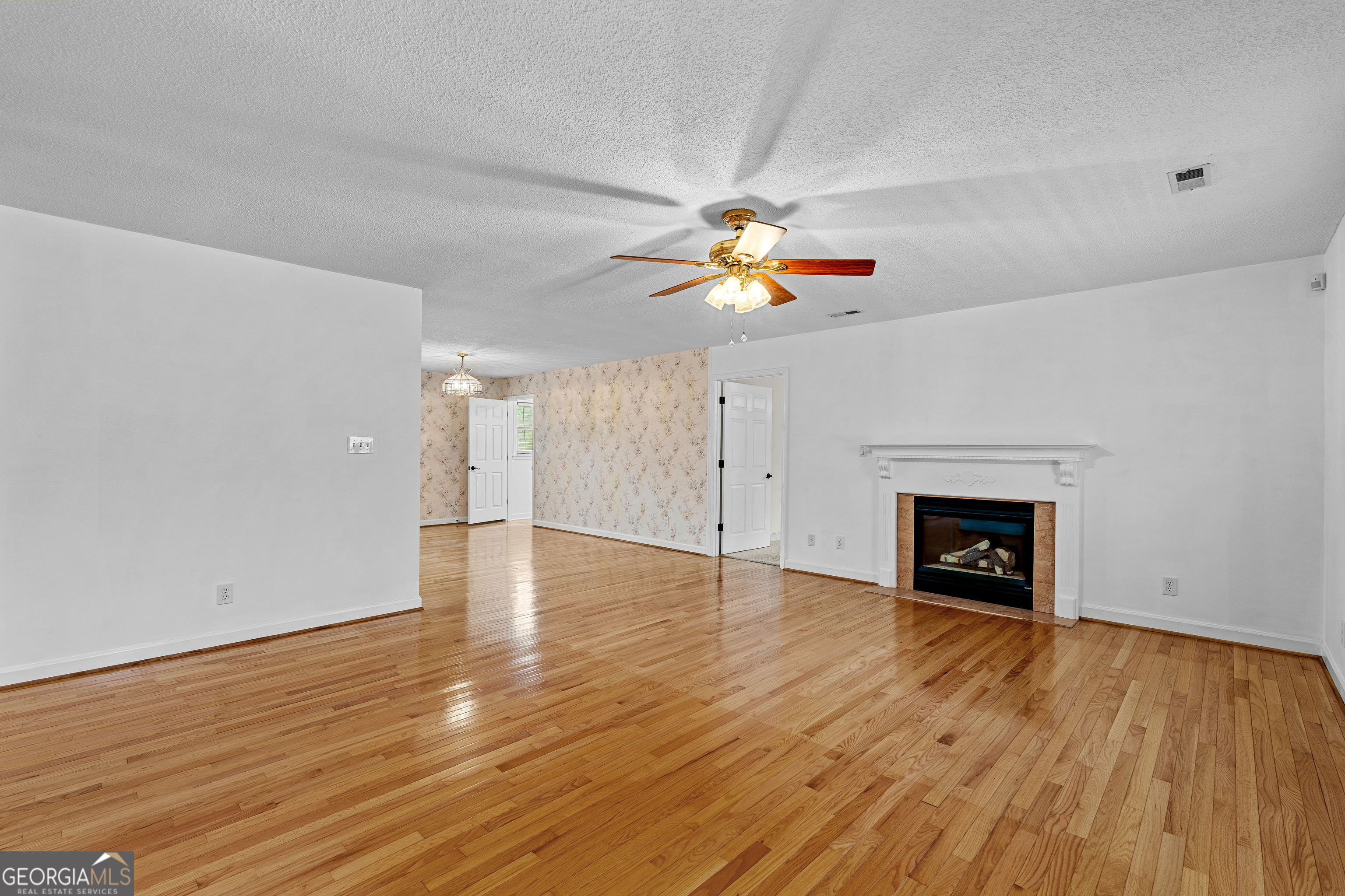 423 Woods Road Brooks, GA 30205 - Photo 10 of 48 a view of an empty room with wooden floor fireplace and a window