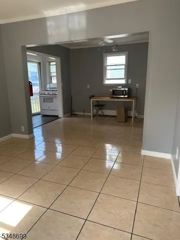 a kitchen with granite countertop a rug a stove a microwave and a counter top space