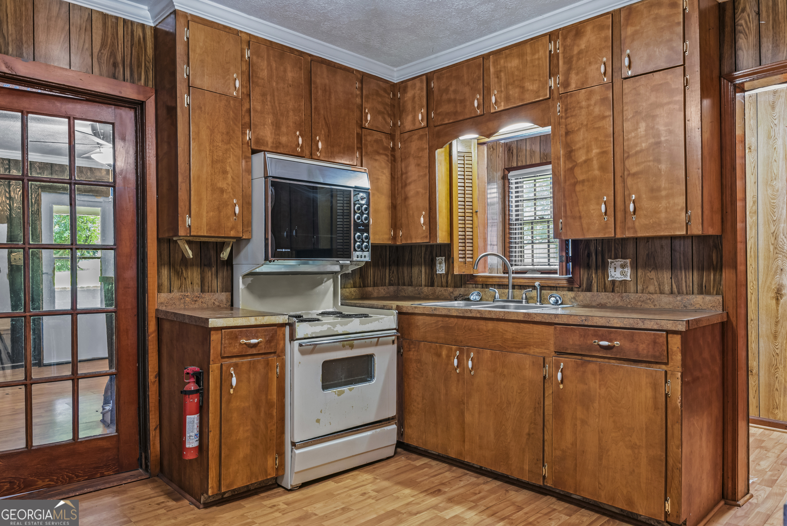 724 Hill Street Madison, GA 30650 - Photo 16 of 36 a kitchen with stainless steel appliances granite countertop a stove a sink and a microwave