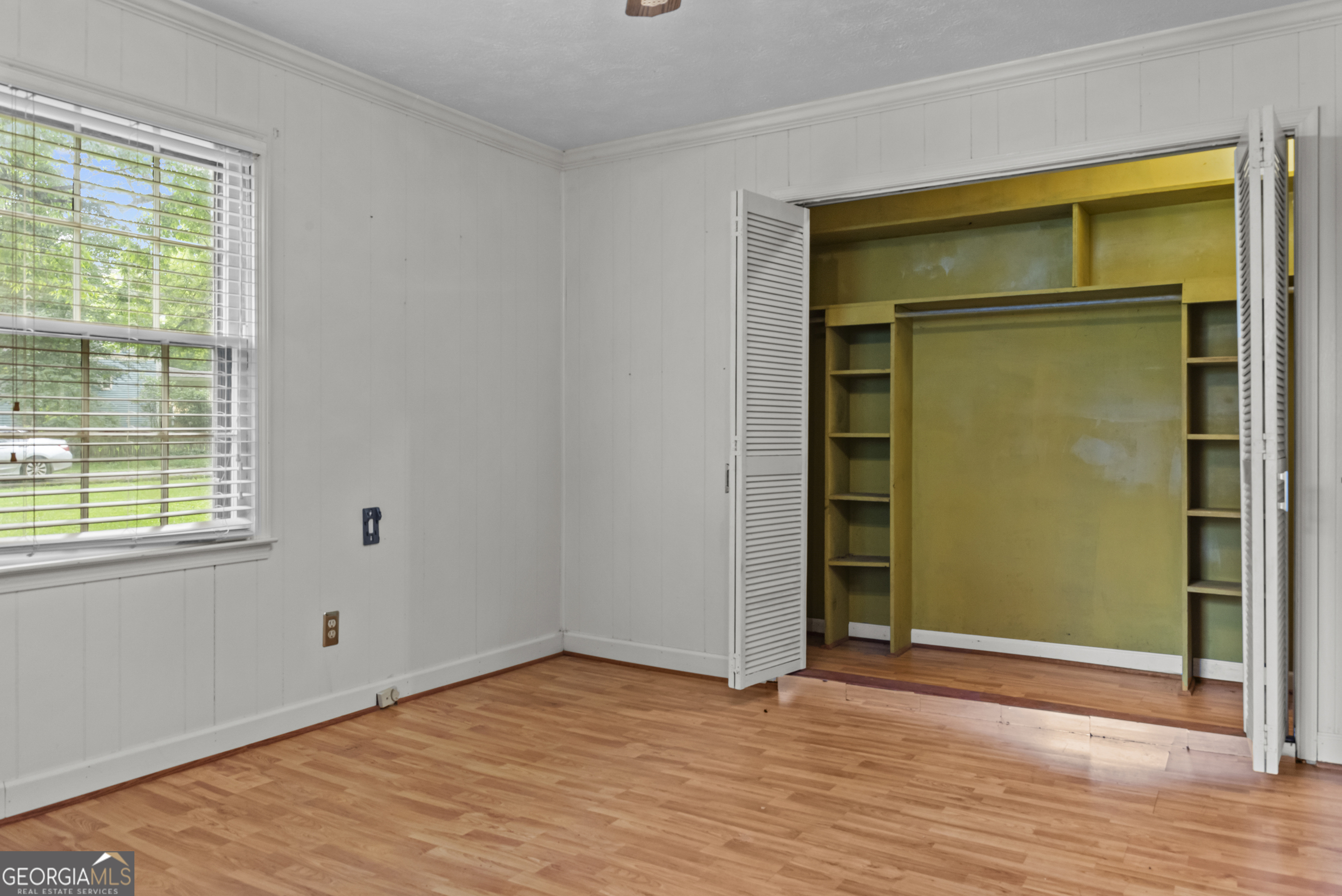 724 Hill Street Madison, GA 30650 - Photo 24 of 36 a view of an empty room with wooden floor and a window