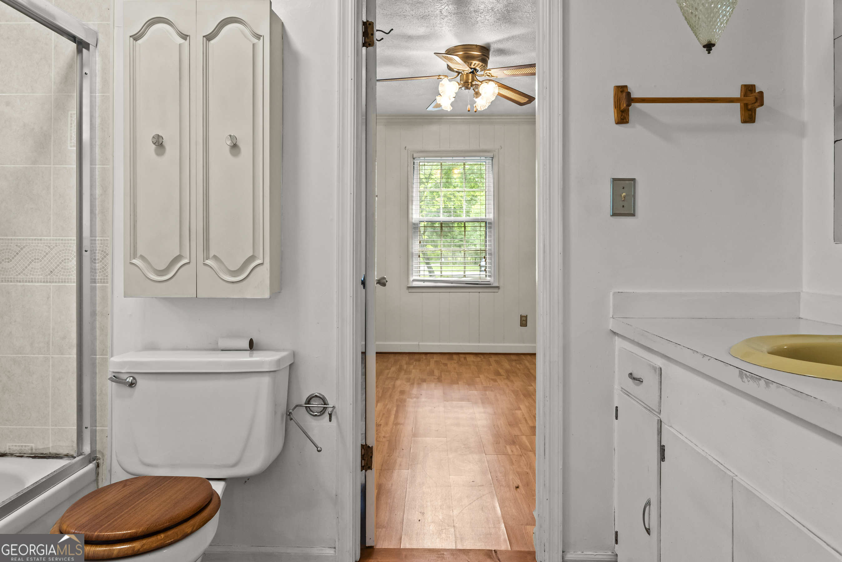 724 Hill Street Madison, GA 30650 - Photo 26 of 36 a bathroom with a toilet a sink and a window