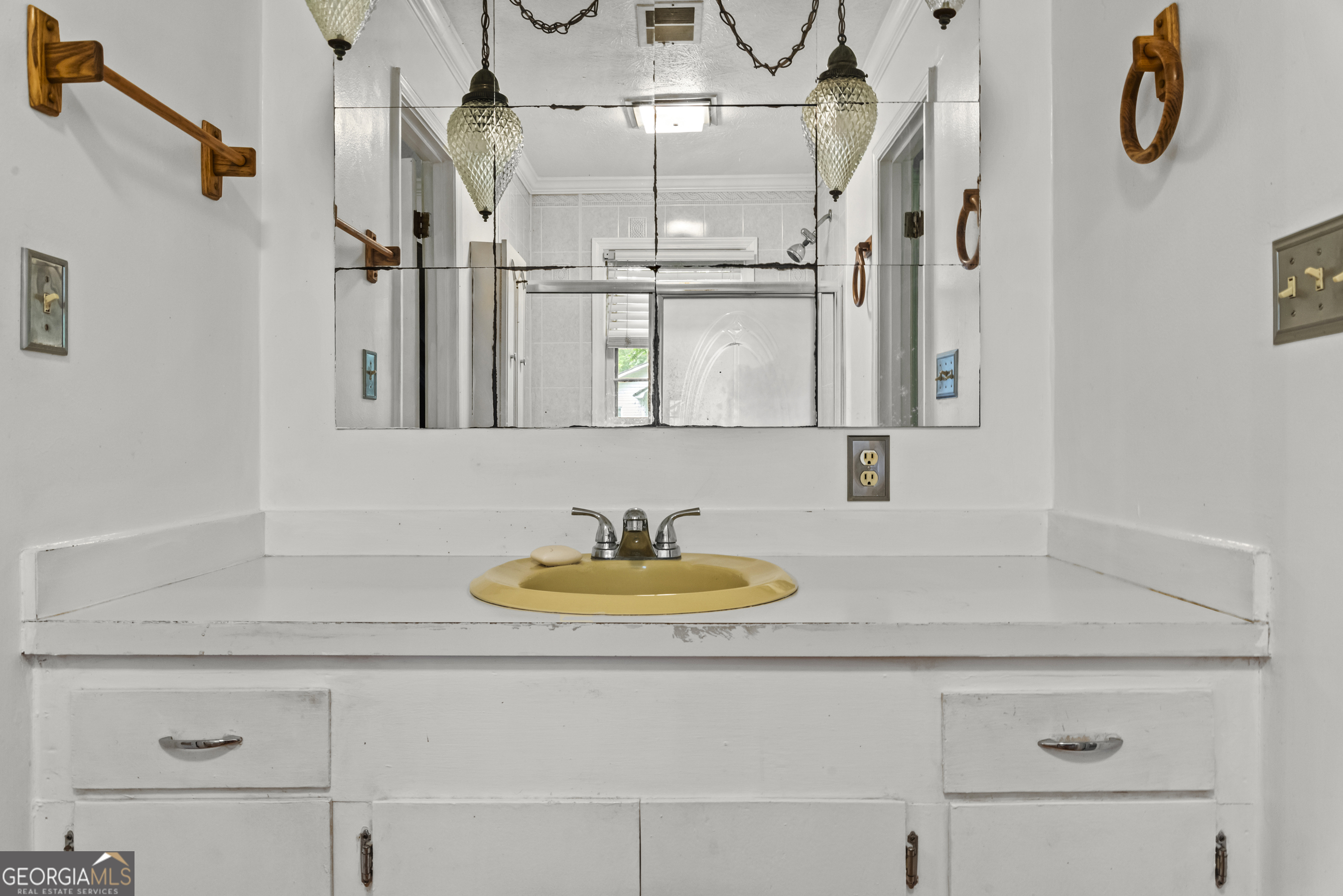 724 Hill Street Madison, GA 30650 - Photo 27 of 36 a bathroom with a sink and a mirror