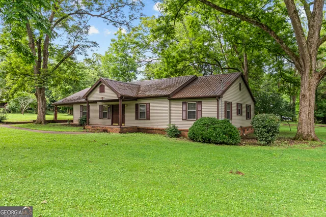 a front view of a house with yard and green space