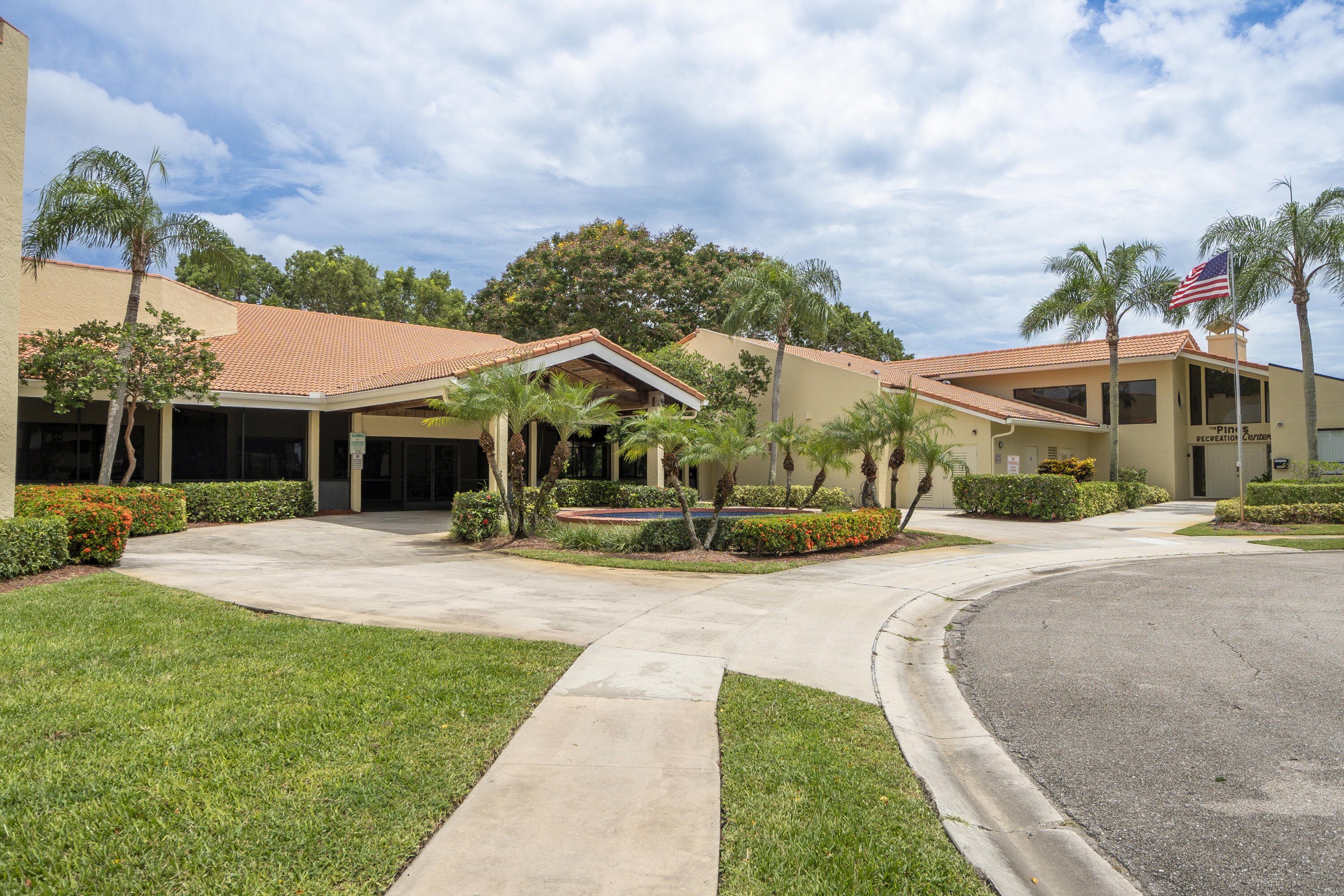 9413 Boca Cove Circle, Unit 1107 Boca Raton, FL 33428 - Photo 23 of 32 a front view of a house with a yard and garage