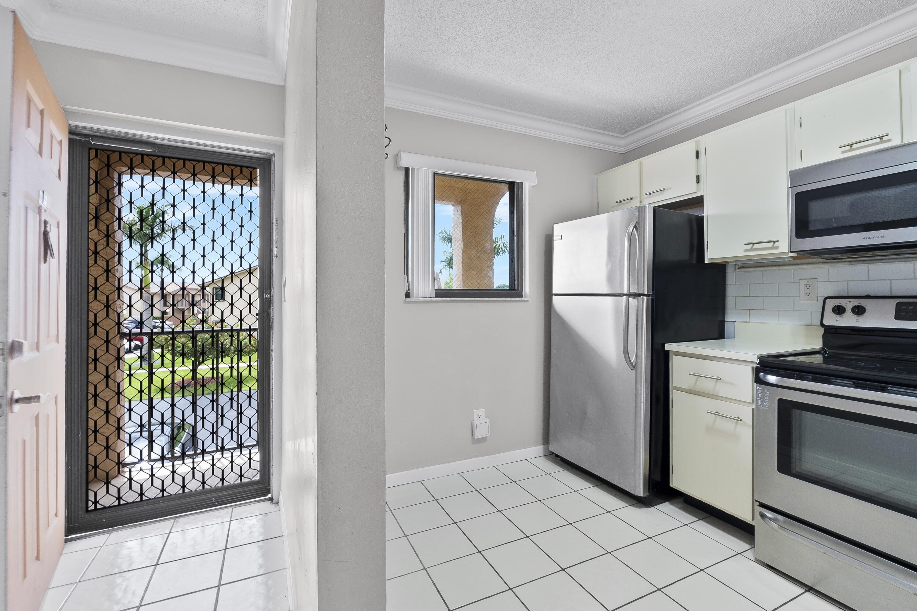 9413 Boca Cove Circle, Unit 1107 Boca Raton, FL 33428 - Photo 9 of 32 a kitchen with stainless steel appliances granite countertop a refrigerator sink and stove