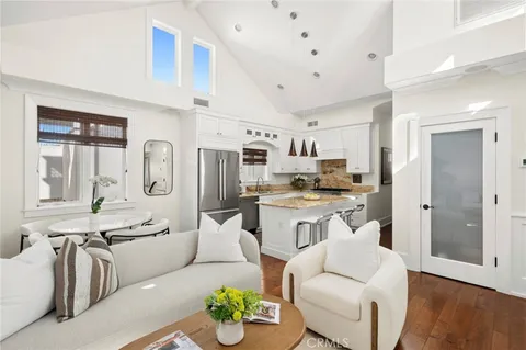 a living room with stainless steel appliances kitchen island granite countertop furniture and a view of kitchen