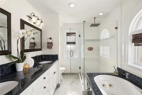 a bathroom with a granite countertop tub sink double vanity granite and glass door