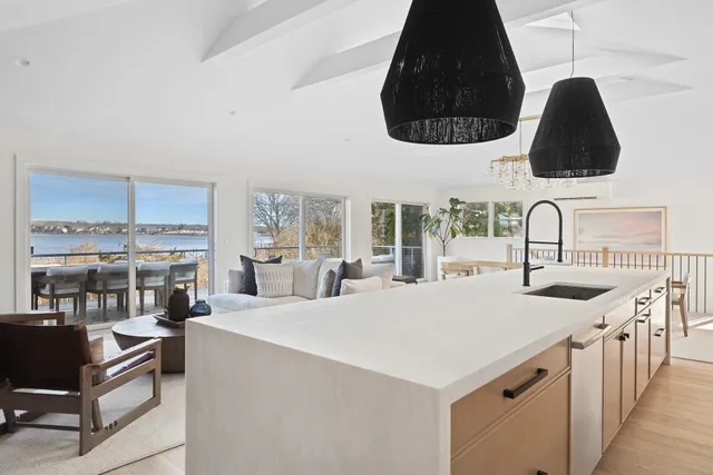 a kitchen with a stove a kitchen island a sink and a dining table with wooden floor