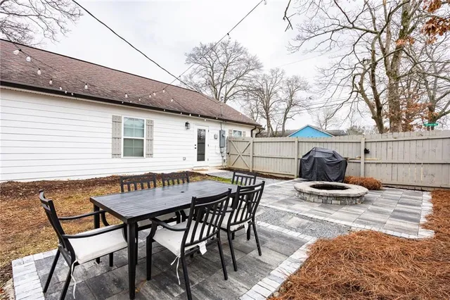 a backyard of a house with barbeque oven table and chairs