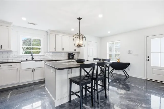 a kitchen with cabinets table and chairs