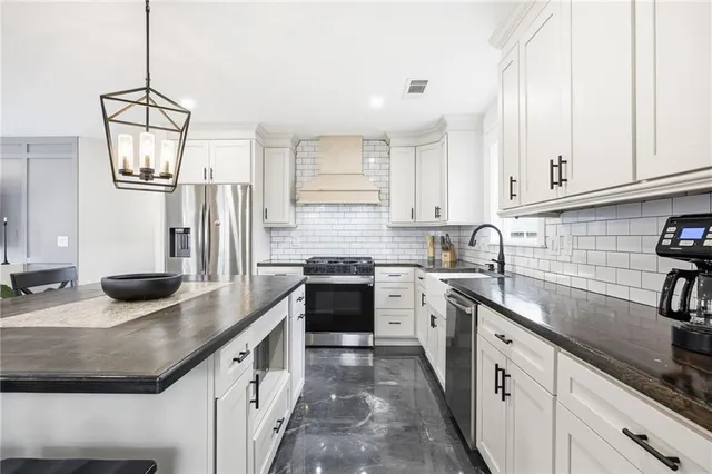 a kitchen with stainless steel appliances granite countertop a sink stove and refrigerator