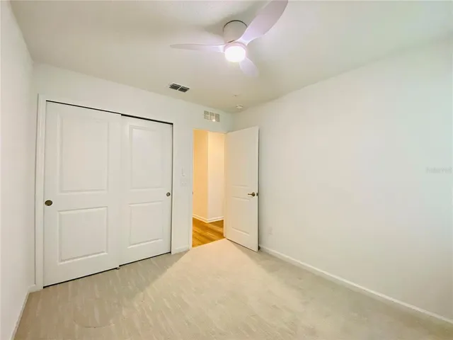 a view of a big room with closet and chandelier fan