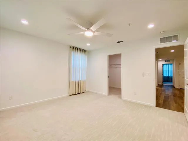 an empty room with fan and entrance