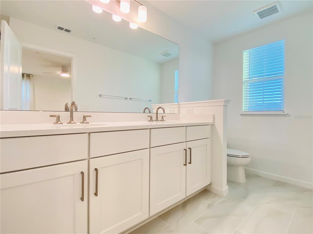1577 Pinecliff Drive Apopka, FL 32703 - Photo 17 of 37 a bathroom with a double vanity sink and a toilet
