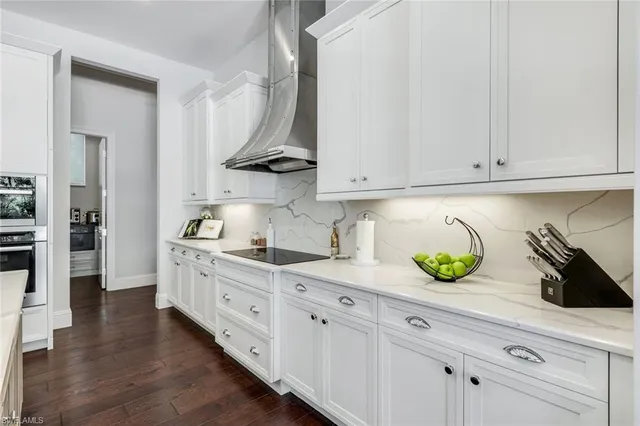 a kitchen with stainless steel appliances kitchen island granite countertop a dining table chairs and sink