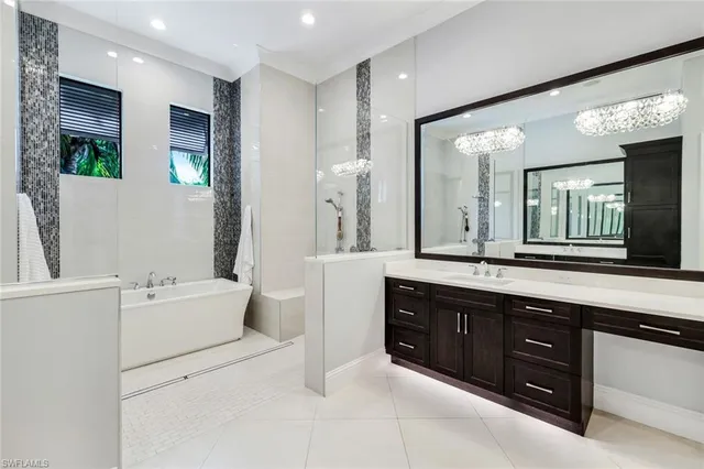 a spacious bathroom with a double vanity sink large mirror and a bathtub