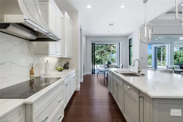 a kitchen with stainless steel appliances a sink a stove and a wooden floors