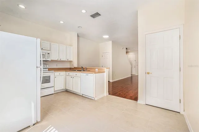 a kitchen with white cabinets and white appliances