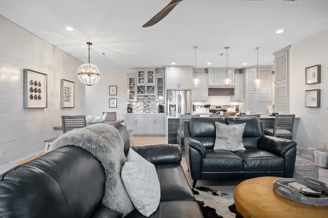a living room with furniture kitchen and a chandelier