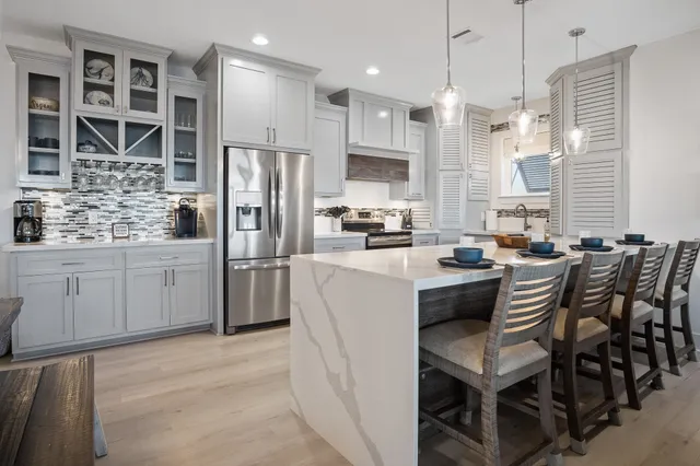 a kitchen with a table chairs refrigerator and microwave