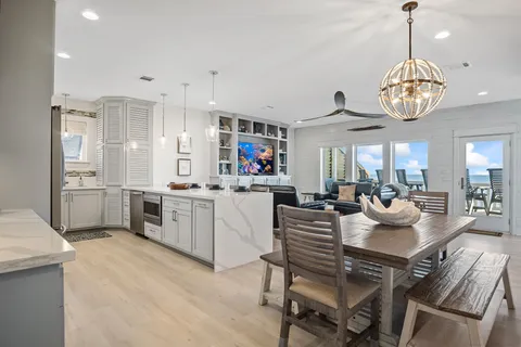 a view of a dining room and livingroom with furniture wooden floor and a chandelier