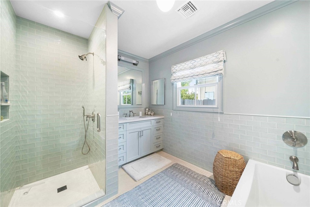 16544 Greenleaf Street Encino, CA 91436 - Photo 15 of 23 a bathroom with a tub sink vanity granite and shower