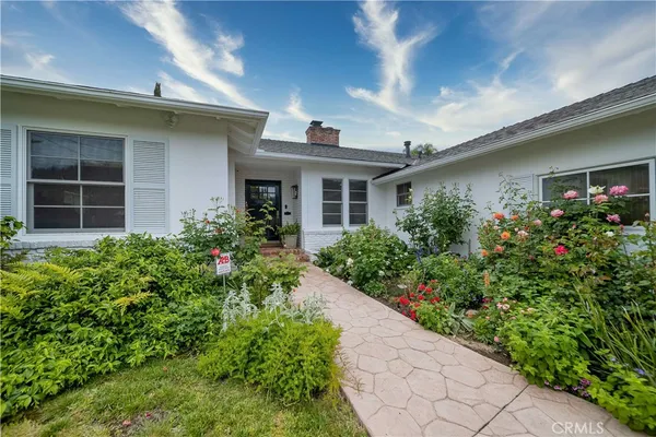a front view of a house with plants