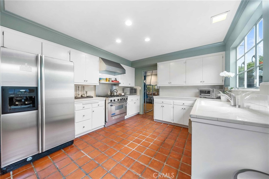 16544 Greenleaf Street Encino, CA 91436 - Photo 8 of 23 a kitchen with white cabinets and stainless steel appliances