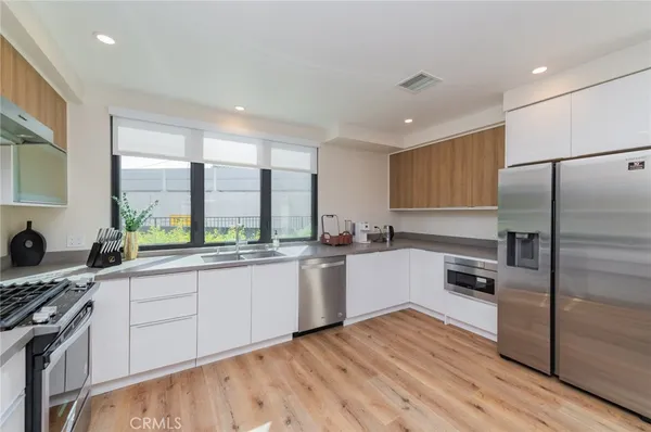 a large kitchen with a large window and stainless steel appliances