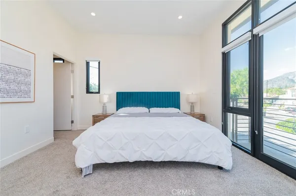 a bedroom with a bed and a large window