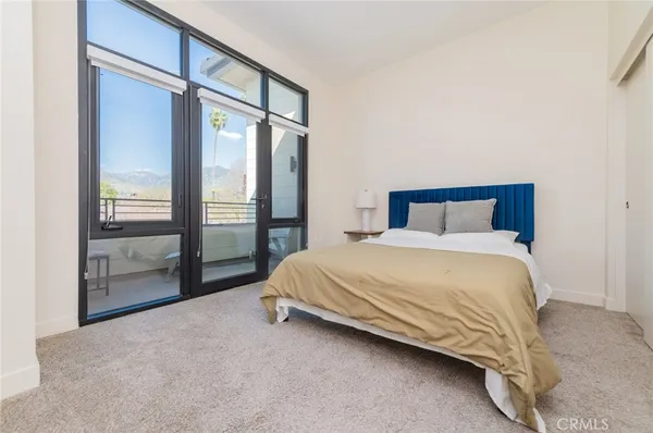 a bed sitting in a spacious bedroom next to a window