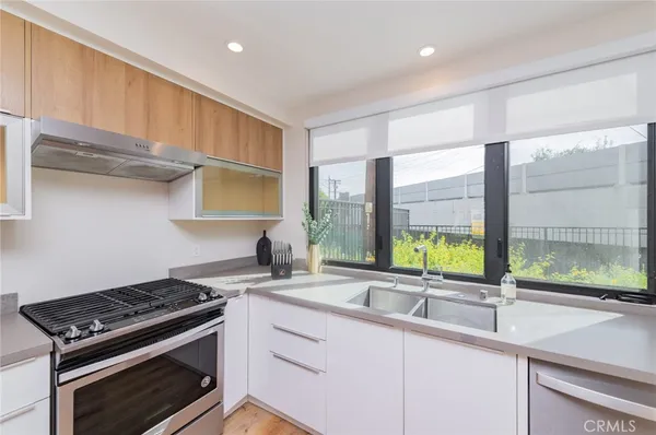 a kitchen with stainless steel appliances a sink a stove and a window